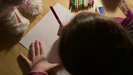 nice little girl child learning new arts skill while drawing on paper with pencils