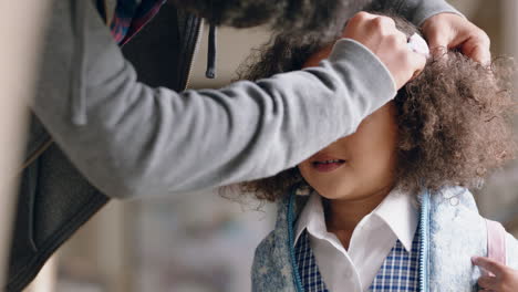 father preparing daughter for school putting cute bow in little girls hair enjoying caring for child