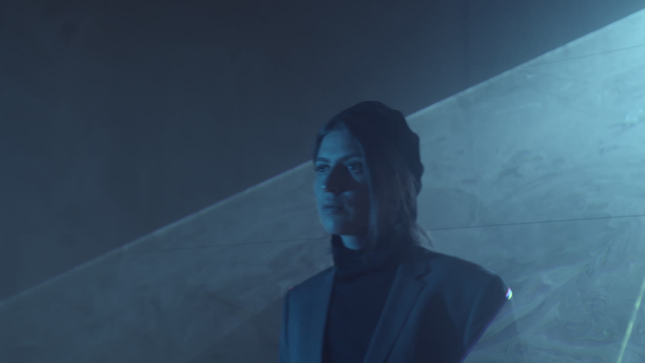 mujer caminando a través de una hoja plana de luz láser en una habitación oscura