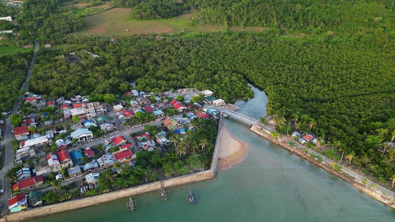 Cảnh quay từ trên cao toàn cảnh Magnesia Del Norte ở Virac, Catanduanes, với một làng barangay ven biển và cây xanh nhiệt đới tươi tốt.