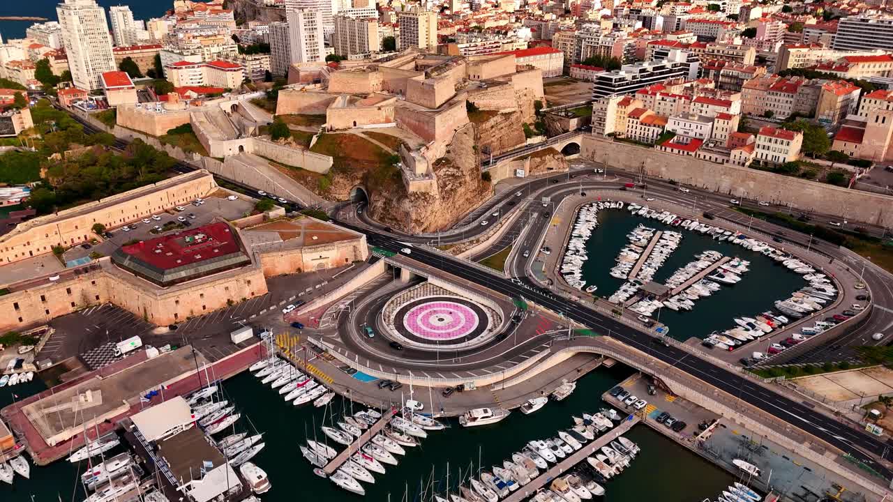 Vista aerea con drone del porto turistico Vieux-Port di Marsiglia e di Fort Saint-Nicolas, con yacht ormeggiati, fortificazioni storiche, strade curve e il paesaggio urbano sul lungomare della Francia meridionale