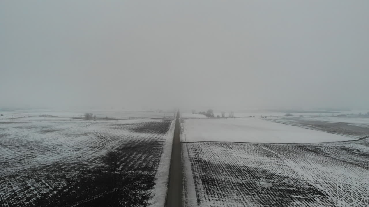 Moving drone shot of empty road in winter with snow