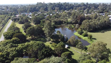 Drone-flying-towards-a-small-lake-and-towards-residential-subdivision-in-Australia