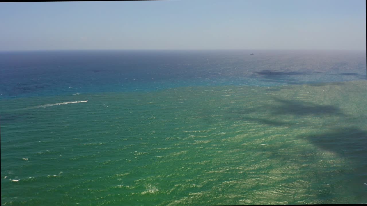 공중 드론은 싱어 아일랜드 해변 근처의 대서양을 천천히 날아다니며 구름이 물 위에 그림자를 가지고 놀고있는 동안 외로운 배를 지나가는 것을보고 있습니다.