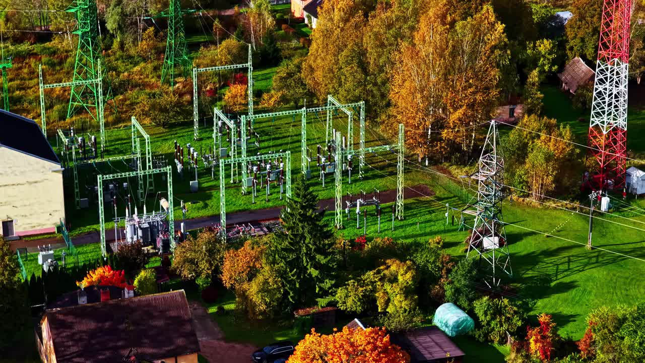 Umspannwerk mit Pylonen und Herbstbäumen in einem Wohngebiet