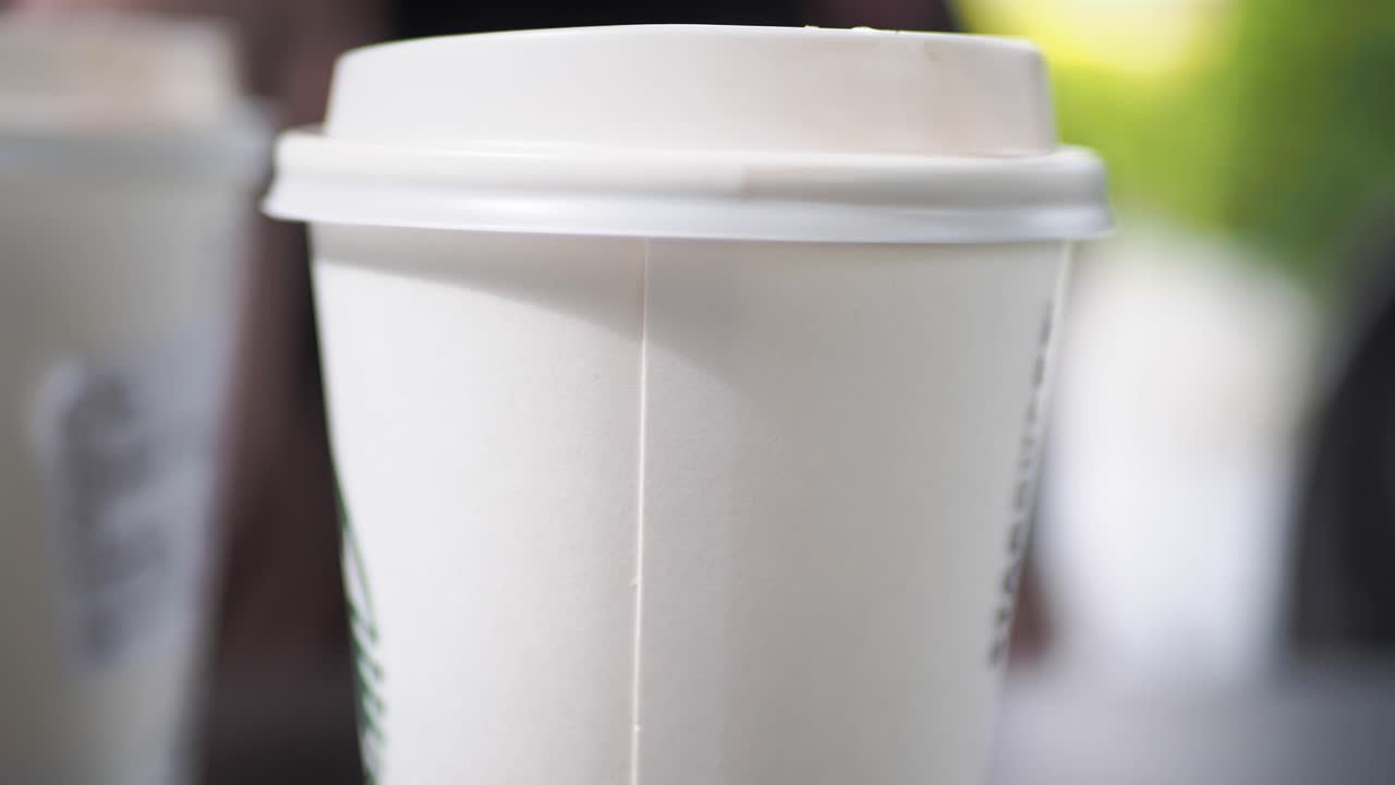 primer plano de una taza de café de papel blanco con tapa