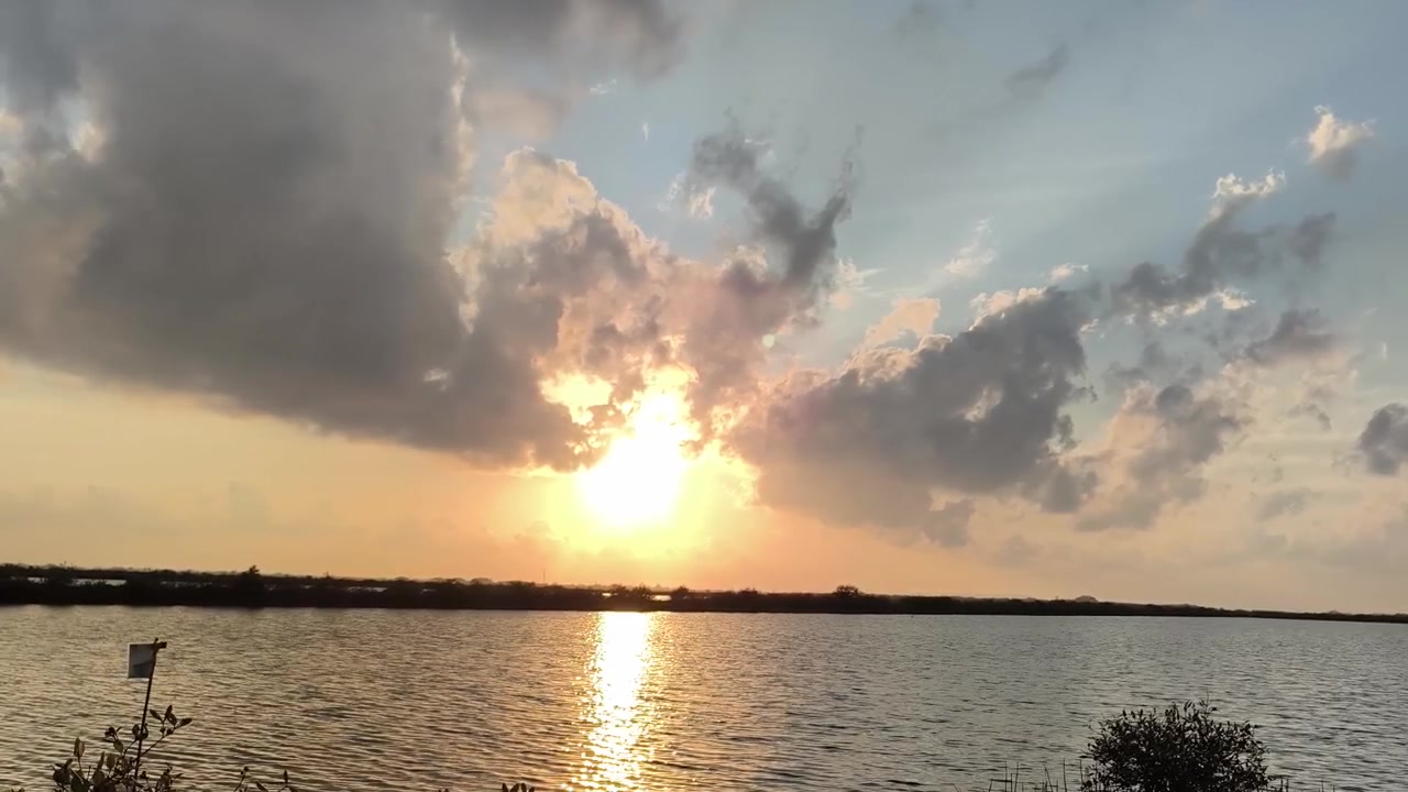 Golden Sunset Over Calm Lake With Dramatic Clouds
