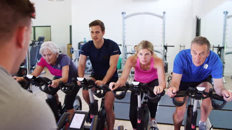 Trainer-Taking-Spin-Class-In-Gym