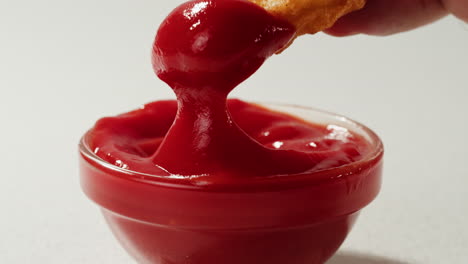 dipping a chicken nuggets into ketchup