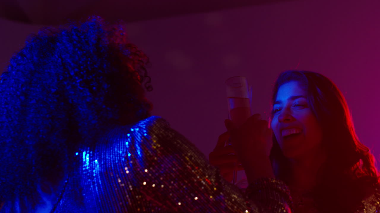 cerca de dos mujeres en un club nocturno o bar celebrando haciendo aclamaciones y bebiendo alcohol 3