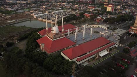 descending drone view looking on the mosque of semarang city at sunset in central java indonesia