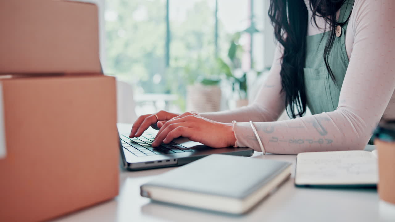 Donna che lavora da casa al laptop con pacchi