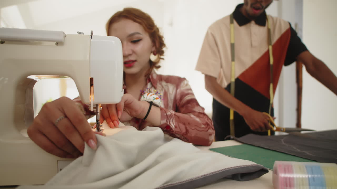 Asian Seamstress Making Dress for Client on Sewing Machine