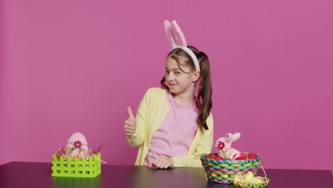 happy schoolgirl with bunny ears showing thumbs up sign