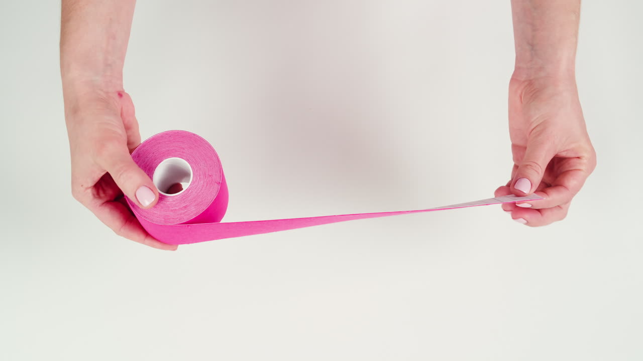 Kinesiology medical taping, doctor Physical therapist applying elastic surgical tape to patient body, treating injured knee young athlete.Post traumatic rehabilitation, sport physical therapy recovery