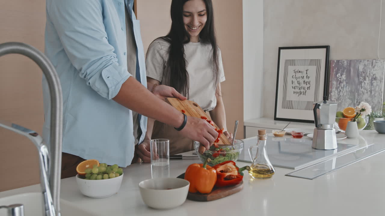 Casal latino conversando enquanto cozinha junto