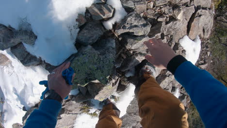 a-man-climbing-a-steep-mountain-rock-by-hand