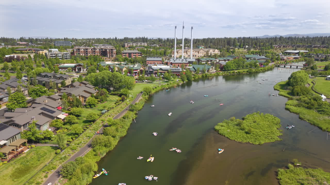 Drone flight over Deschutes River in Bend. People tubing and surfing on the river. Bend Oregon Old Mill District.