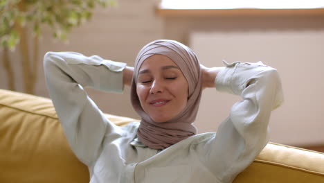 relaxed woman wearing hijab on a sofa