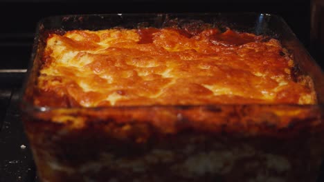 whole view of freshly made lasagna with crispy golden cheese melted topping fresh after cooking in hot oven. indulgent delicious italian pasta based dish ready to eat