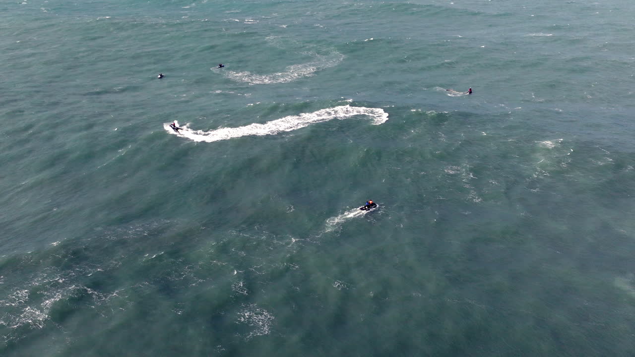 Jet ski teams exploring iconic famous Nazaré waves aerial drone shot. Portugal, Europe