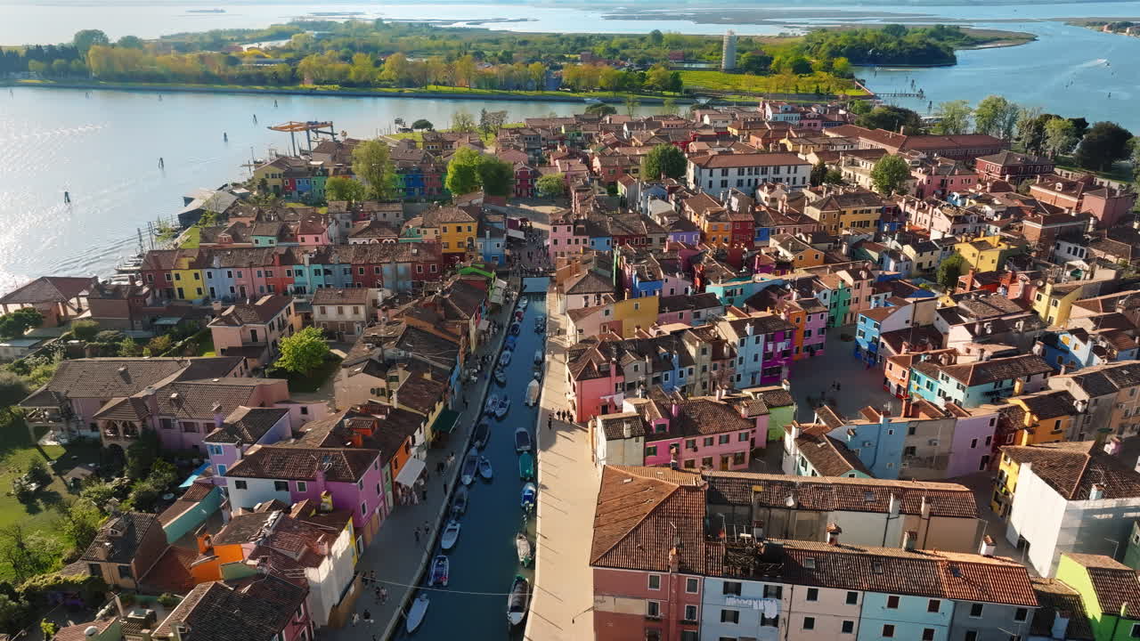 Aerial drone view of boats on the sides of a canal near the colourful houses of Burano Island, Italy