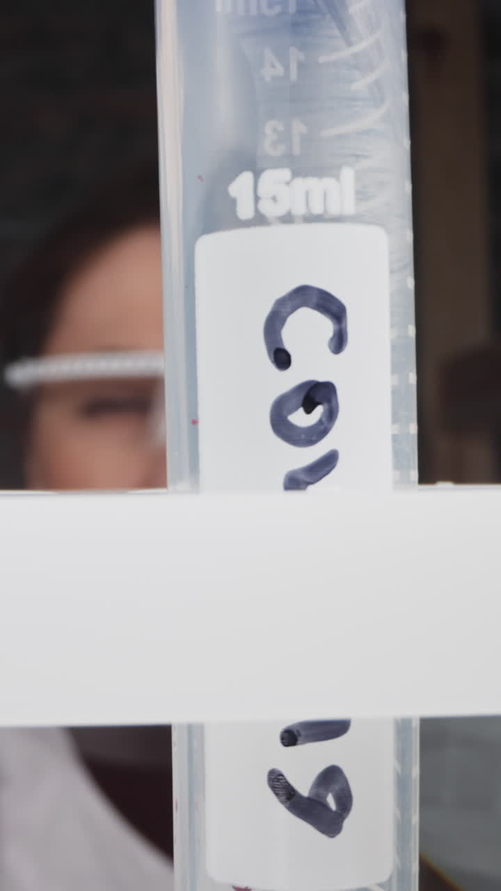 Nurse puts test tube with patient blood and tag Covid into rack sell slow motion. Probe lens footage of dangerous virus research macro view