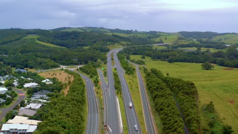 calzada a lo largo de los exuberantes campos verdes y colinas que conectan byron bay y brisbane en queensland, australia