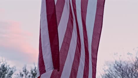 slow motion: close-up van een rafelige amerikaanse vlag terwijl de camera omhoog kantelt en bovenaan een adelaarsembleem onthult
