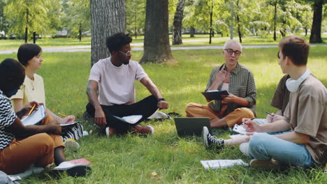 multiethnic students and female teacher at outdoor lesson in park