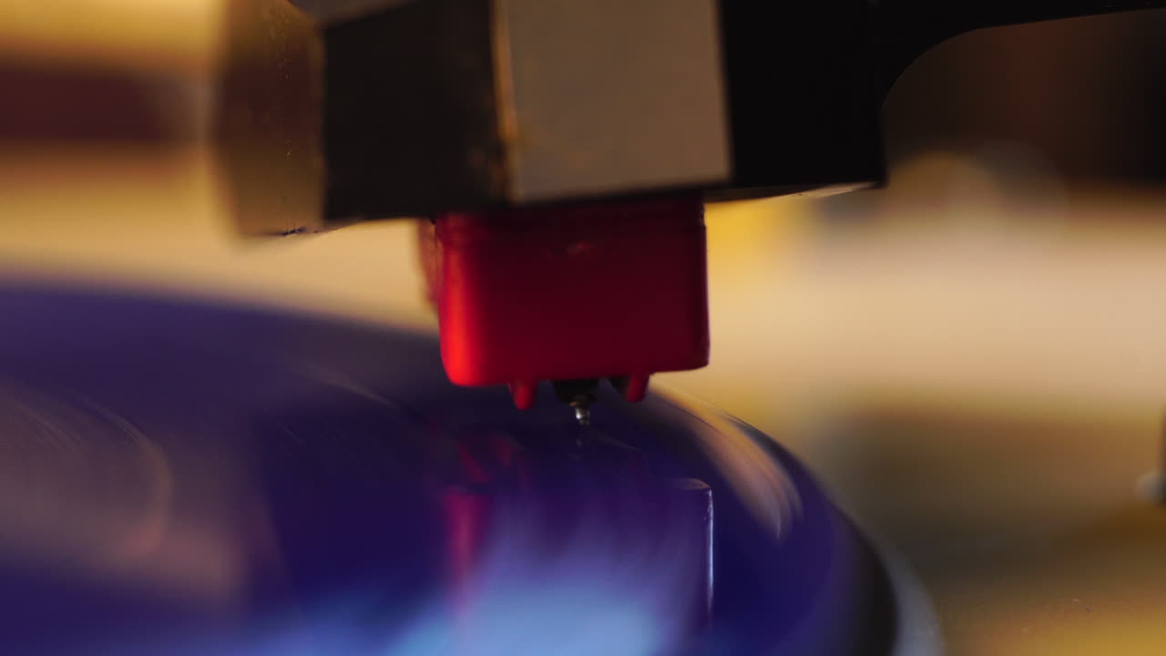 Ago di cristallo per grammofono su un disco in vinile blu in rotazione, primo piano macro