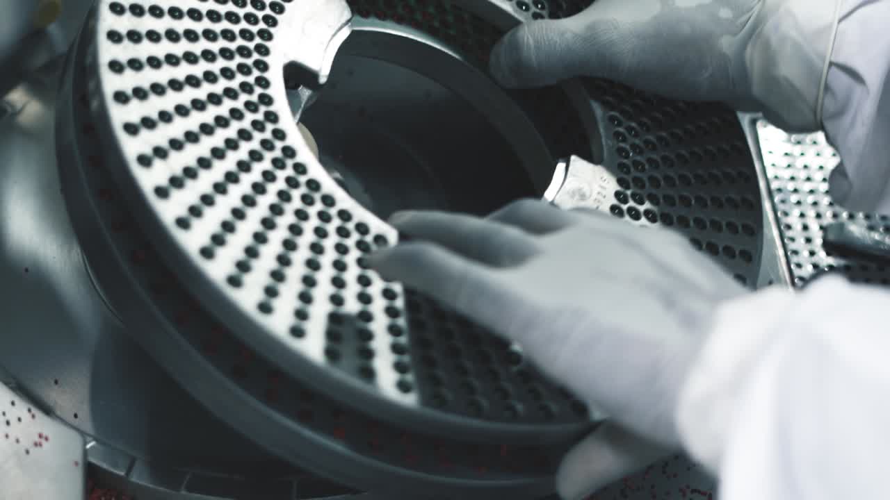 recipientes circulares inoxidables llenos de pastillas médicas listas para el proceso de envasado en la fábrica de medicamentos