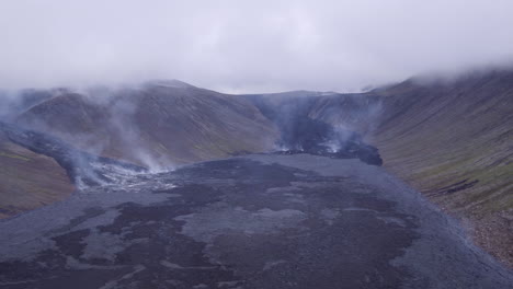 Fagradalsfjall-volcano-Iceland,-tracking-aerial-from-right-to-left-above-cooling-lava-fields