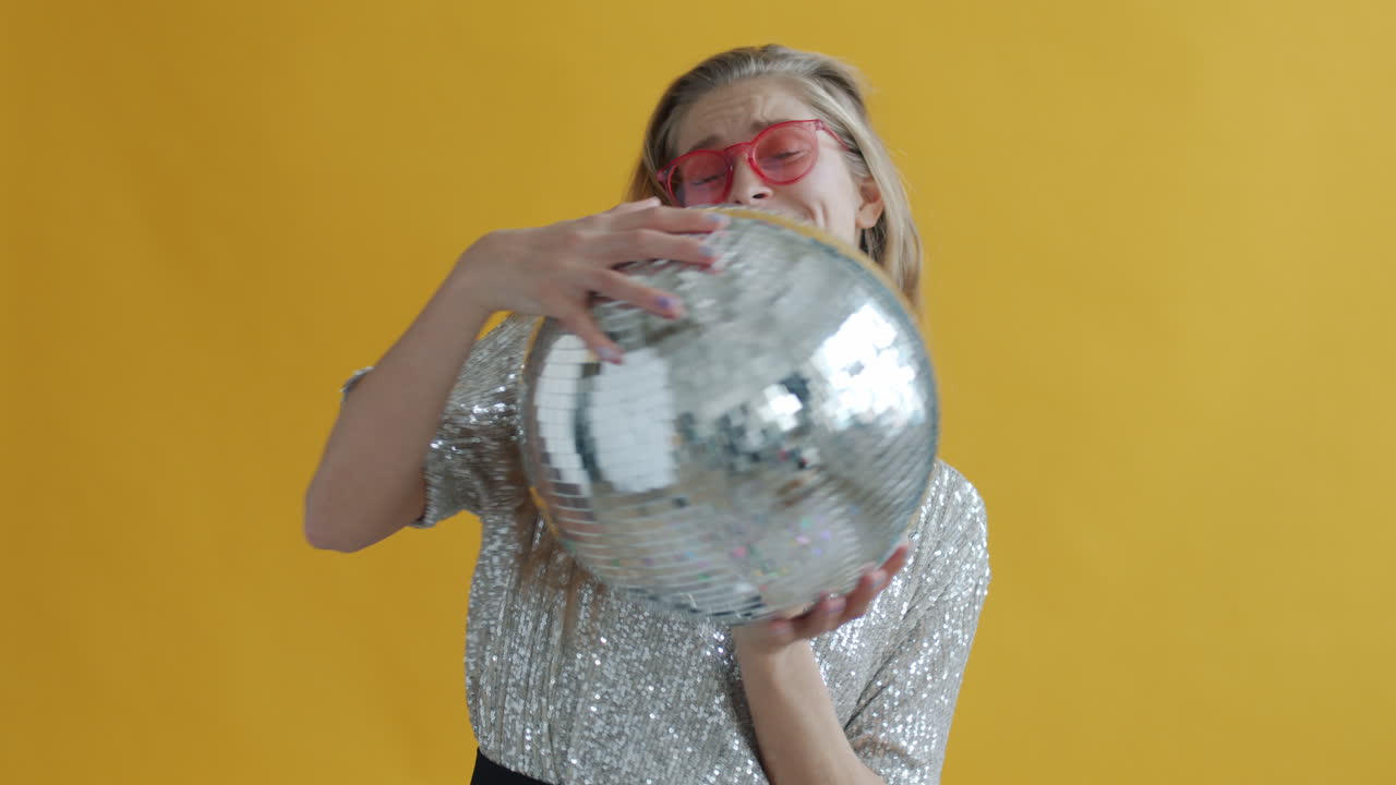 Woman holding a disco ball in a party-like environment