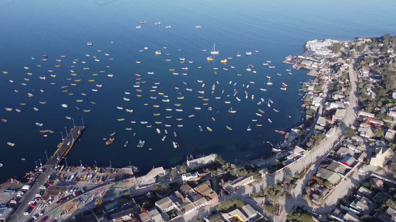 Flyover of picturesque fishing village marina, boats in Tongoy Chile