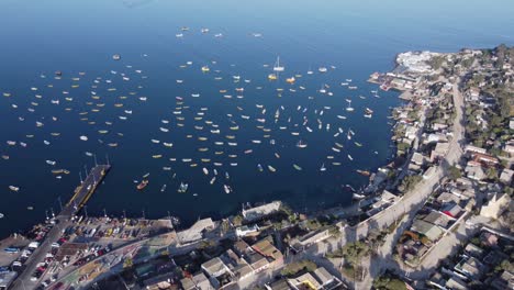 Flyover-of-picturesque-fishing-village-marina,-boats-in-Tongoy-Chile