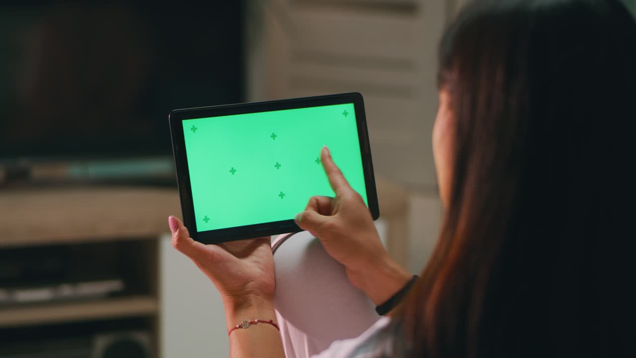 익명의 여성이 태블릿에서 사진을 스와이프하고 있습니다.