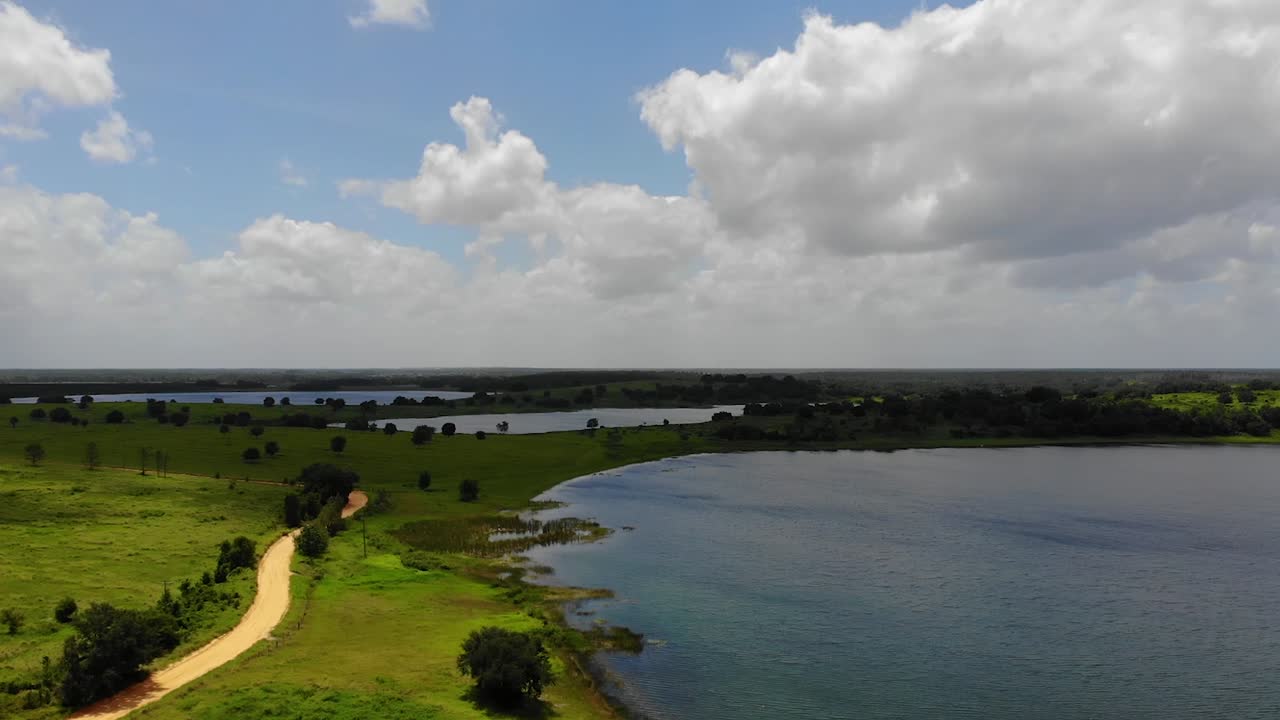 toma aérea del antiguo camino de tierra al lado del lago