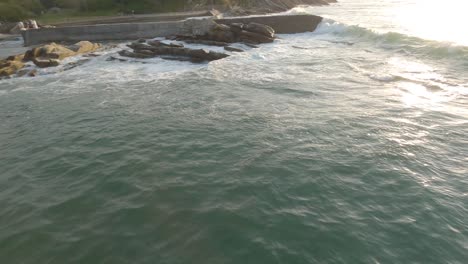 Drone-flying-at-low-altitude-along-rocky-coast-of-Hendaye,-Pyrenees-Atlantiques,-France