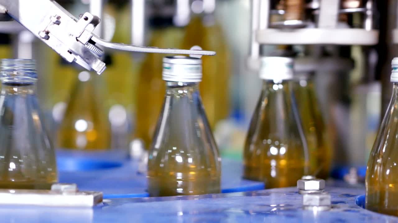 línea de máquina automática para llenar agua en una botella de vidrio. embotellado de bebidas a base de hierbas en botellas de vidrios. producción de agua potable y bebidas.
