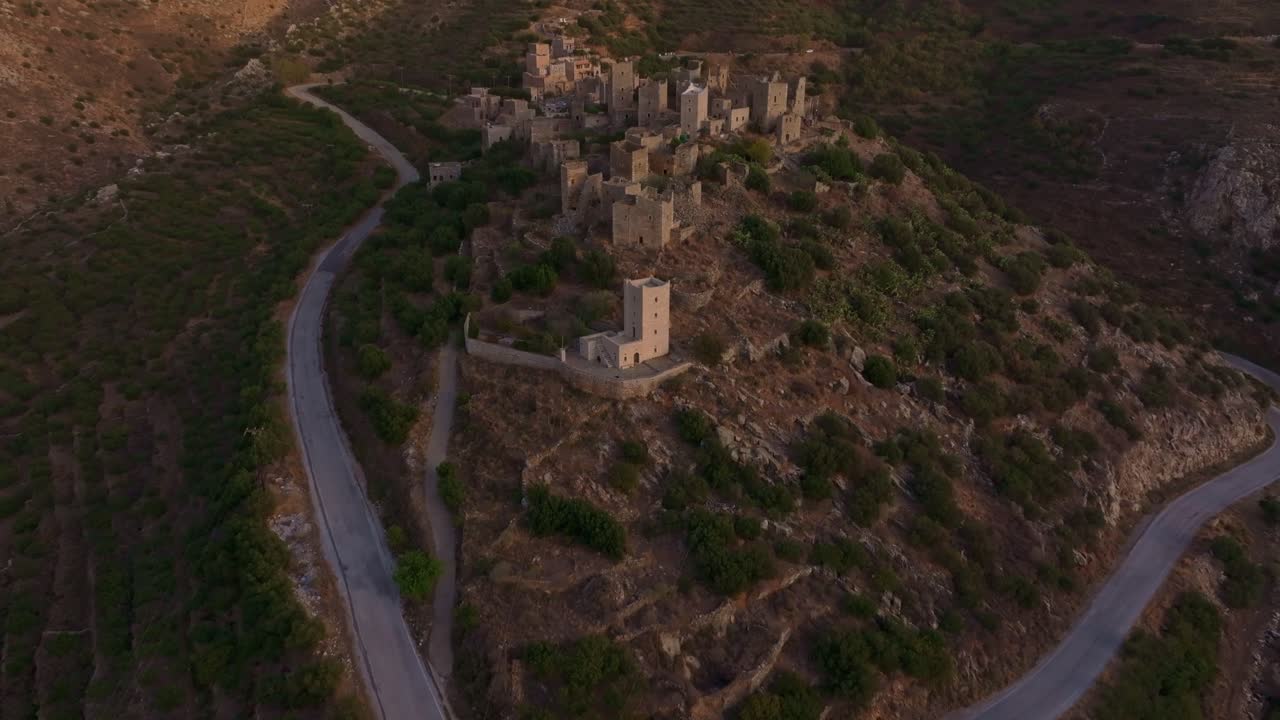 Panorama crepuscolare di rovine storiche e dolci colline, Vathia, Grecia