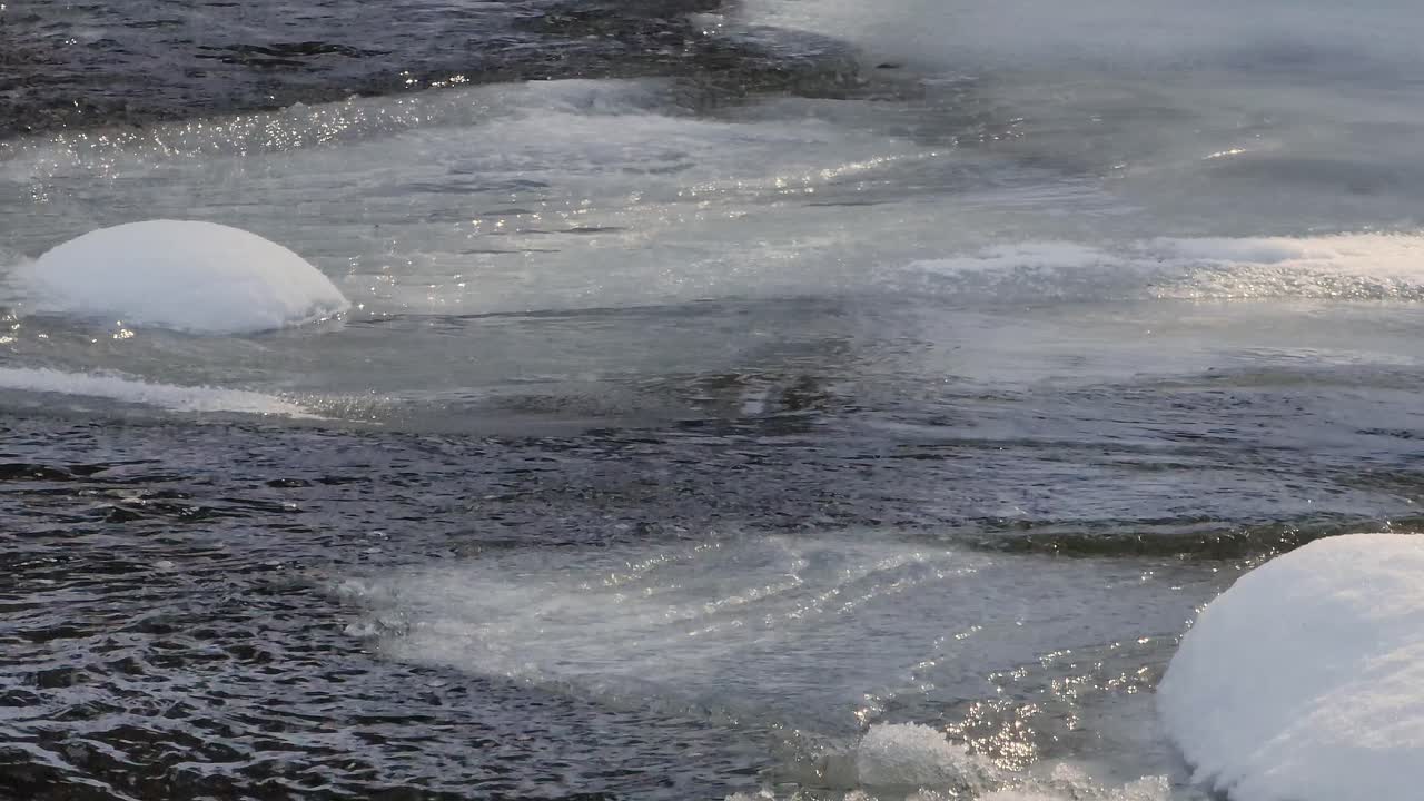 맑은 겨울날 얼음이 녹으면서 물이 얼음 강을 따라 흐릅니다.