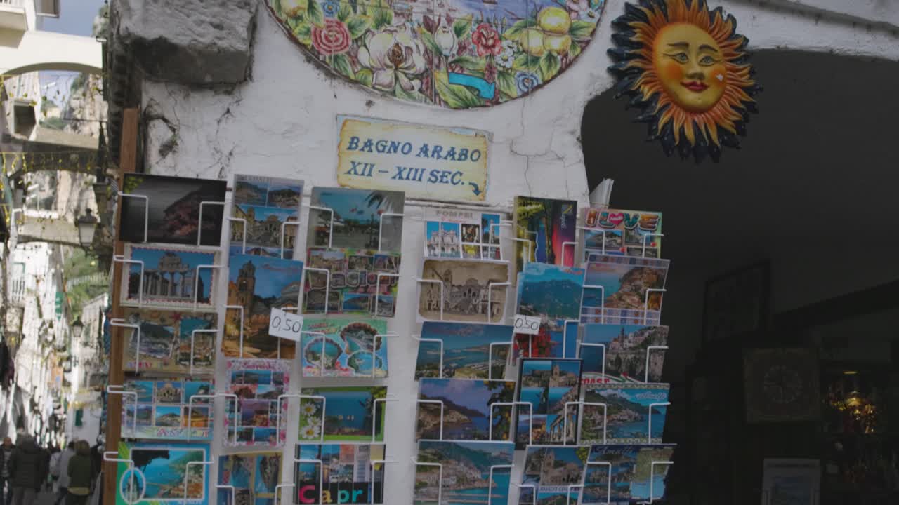 Cartões postais de Amalfi na rua, em plano picado.