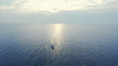 deportista nadando en kayak en el mar al atardecer. vista aérea kayakista montando en el mar