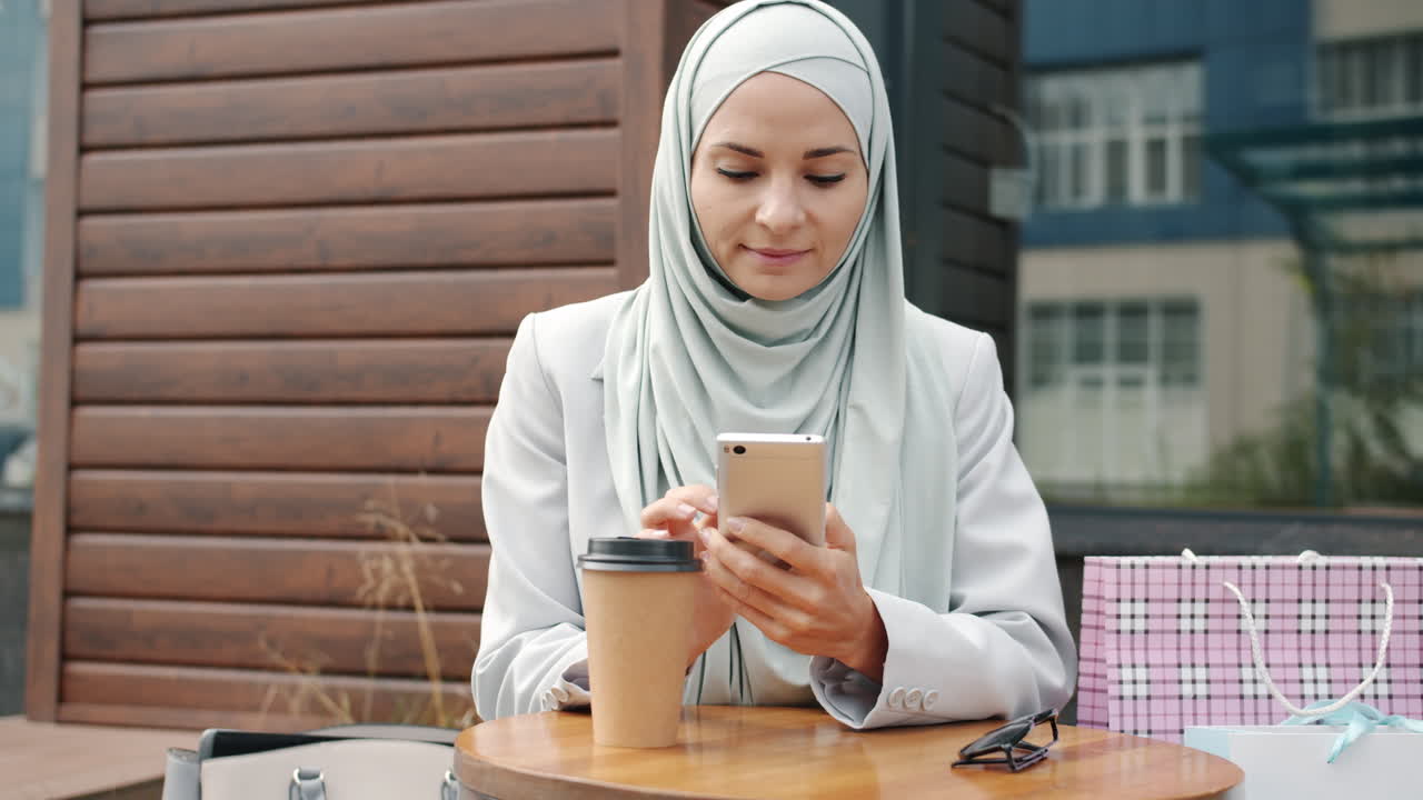 mujer usando un teléfono inteligente en un café