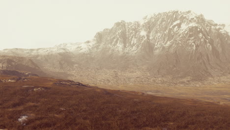 rocky desert landscape with sparse vegetation and mountains peaks