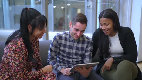 cheerful multiethnic friends browsing on tablet