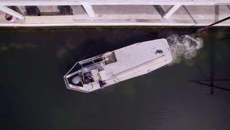 the motorboat gracefully departs from the dock, its engine humming as it sets out on its journey across the water