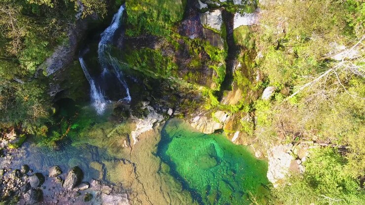 Cascata Virje, flusso d'acqua turchese incontaminata che cade, veduta aerea sopra la valle di pietra, Torrente Glijun, Monte Kanin, Slovenia.