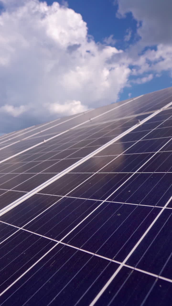 Blue solar panel close-up. Alternative source of electricity on solar energy farm. Source of ecological renewable energy. Motion camera back. Vertical video
